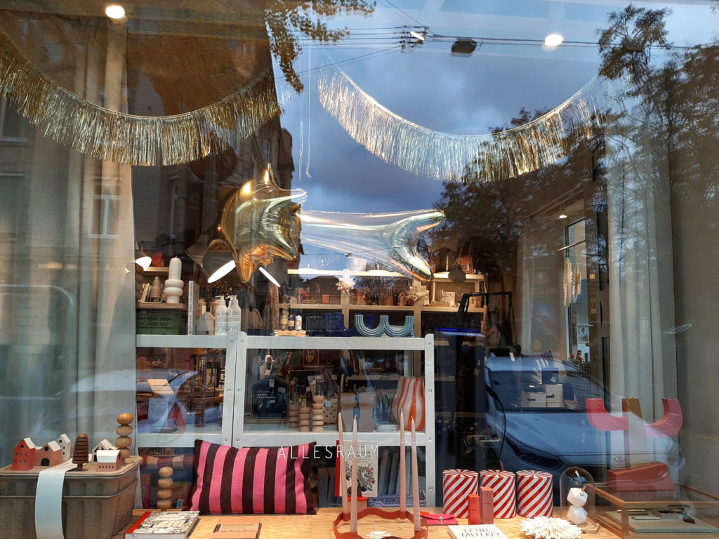 Schaufensterscheibe mit Goldgirlande und wohnaccessoires